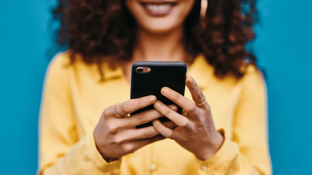 Woman in yellow shirt holding cell phone